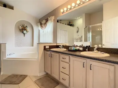 a bathroom with two sinks and a bath tub and a tubermott at Magic Orlando Villa, You are in Disney in Kissimmee