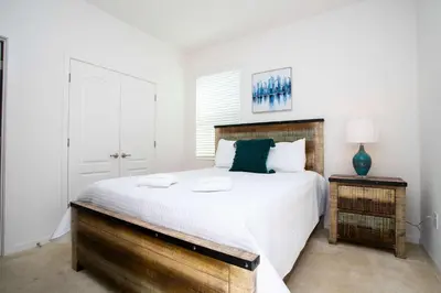 a bedroom with a large bed with a wooden headboard at Exclusive 8BR Family Villa - Pool, BBQ, Game Room & Themed Bedrooms! in Kissimmee