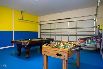 a play room with a pool table and a garage at Exclusive 8BR Family Villa - Pool, BBQ, Game Room & Themed Bedrooms! in Kissimmee