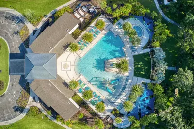 an overhead view of a swimming pool with palm trees at Exclusive 8BR Family Villa - Pool, BBQ, Game Room & Themed Bedrooms! in Kissimmee