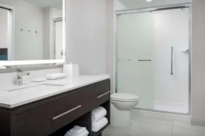 a bathroom with a sink and a toilet and a shower at Home2 Suites Orlando Southeast Nona in Orlando