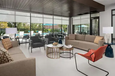 a living room with couches and chairs and a table at Hampton Inn Orlando Southeast Nona in Orlando