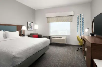 a hotel room with a bed and a television at Hampton Inn Orlando Southeast Nona in Orlando